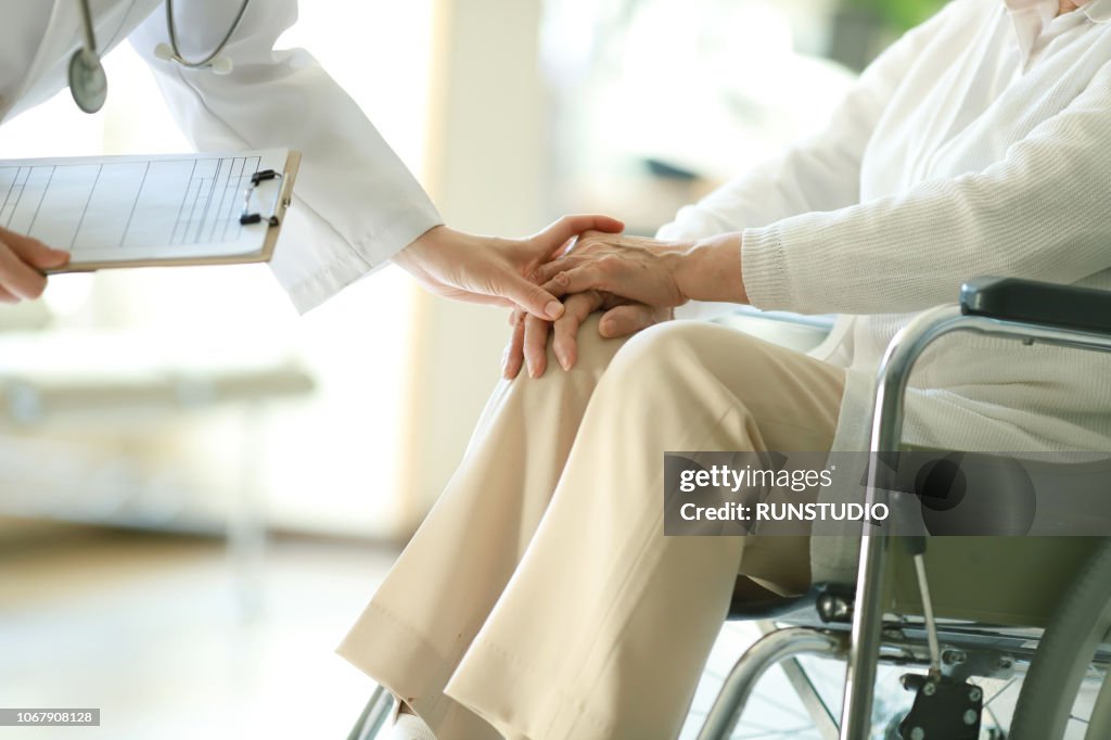 Doctor examining patient in wheelchair