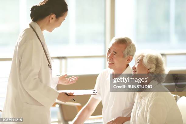 doctor talking to senior couple in hospital - japan and medical and hospital stock pictures, royalty-free photos & images