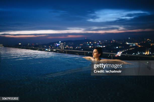 night swimming in the pool in malaysia - infinity pool stock pictures, royalty-free photos & images