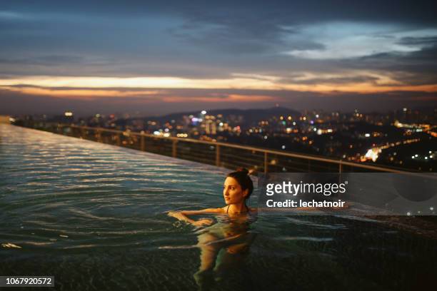 joven teniendo una noche nadar en la piscina en malasia - hotel de lujo fotografías e imágenes de stock
