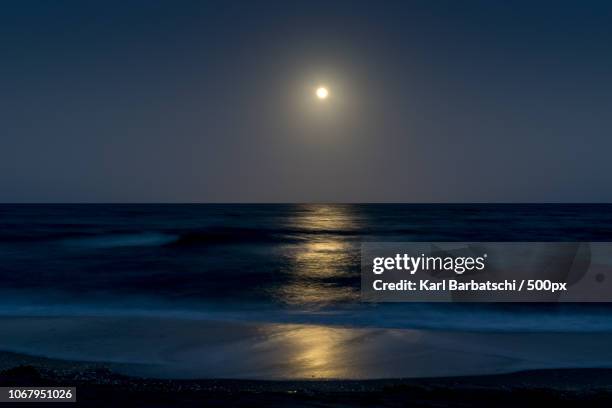 moon shining over sea - beach night stockfoto's en -beelden