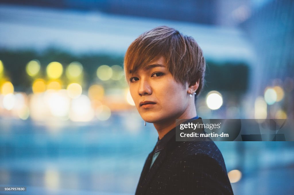Portrait of young japanese man in Osaka city at twilight