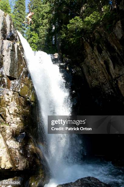 man jumping off waterfall in idaho. - waterfall jump stock pictures, royalty-free photos & images