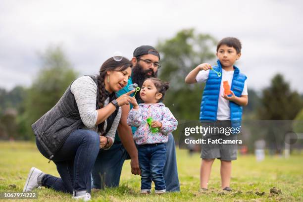 en familj umgås på parken och blåser bubblor tillsammans - indian food bildbanksfoton och bilder