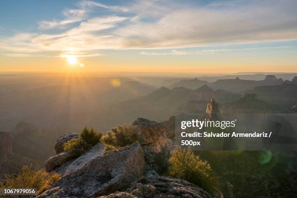 sun over mountain peaks - armendariz stock pictures, royalty-free photos & images