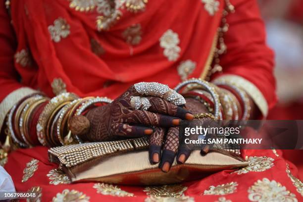 An Indian Muslim bride, her hands decorated with mehndi art, participates in a mass marriage in Ahmedabad on December 3, 2018. - Some 65 Muslim...