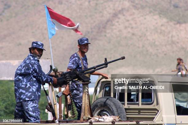 Yemeni security forces stand on the back of a pick up truck mounted with a heavy machine gun at a checkpoint in the former Al-Qaeda in the Arabian...