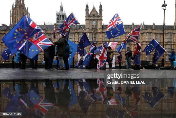 Pro-European Union , anti-Brexit demonstrators wave Union and EU flags as they protest opposite the Houses of Parliament in London on December 3,...