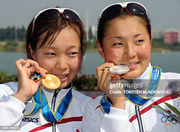 Gold medallist Mariko Adachi of Japan poses for a picture with fellow silver medalist Akane Tsuchihashi after winning the woman's triathlon...