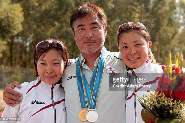 Medal winners Mariko Adachi and Akane Tsuchihashi of Japan pose with their coach Kenjiro Iijima after receiving the medals won in the Women's...