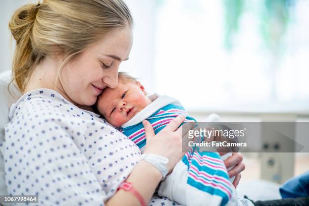 ny mamma håller sin bebis i sjukhussäng - newborn bildbanksfoton och bilder