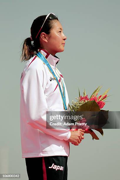 Akane Tsuchihashi of Japan listens to her national anthem with the Silver medal won in the Women's Individual Triathlon at the Triathlon Venue during...