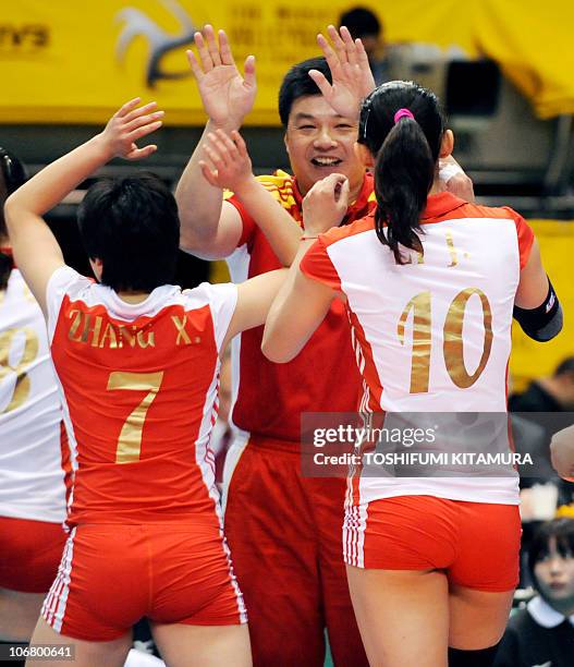 China's head coach Yu Juemin celebrates the victory over Cuba with his players, Zhang Xian and Li Juan during their final round/Place 9th-12th match...