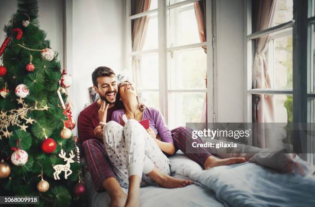 peaceful christmas morning. - young couple reading book stock pictures, royalty-free photos & images