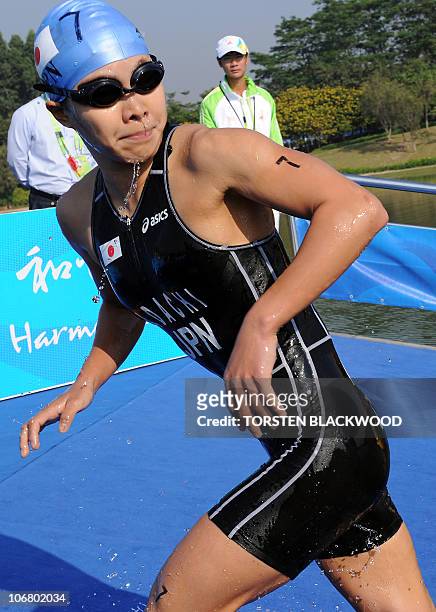 Mariko Adachi of Japan looks over her shoulder on her way to gold in the woman's triathlon at the 16th Asian Games in Guangzhou on November 13, 2010....
