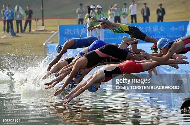 The 11 competitors dive in at the start of the women's triathlon at the 16th Asian Games in Guangzhou on November 13, 2010. Mariko Adachi of Japan...