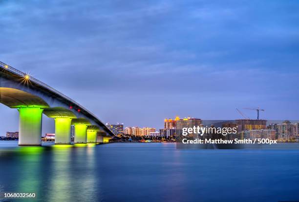 dusk over modern city with illuminated bridge - sarasota stock pictures, royalty-free photos & images