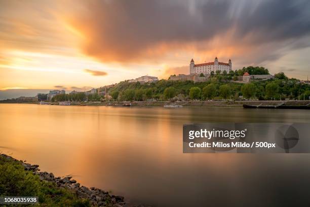 castle and river at sunset, bratislava, slovakia - bratislava stockfoto's en -beelden