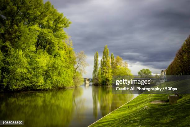 water canal with trees and storm clouds in background - yvelines foto e immagini stock