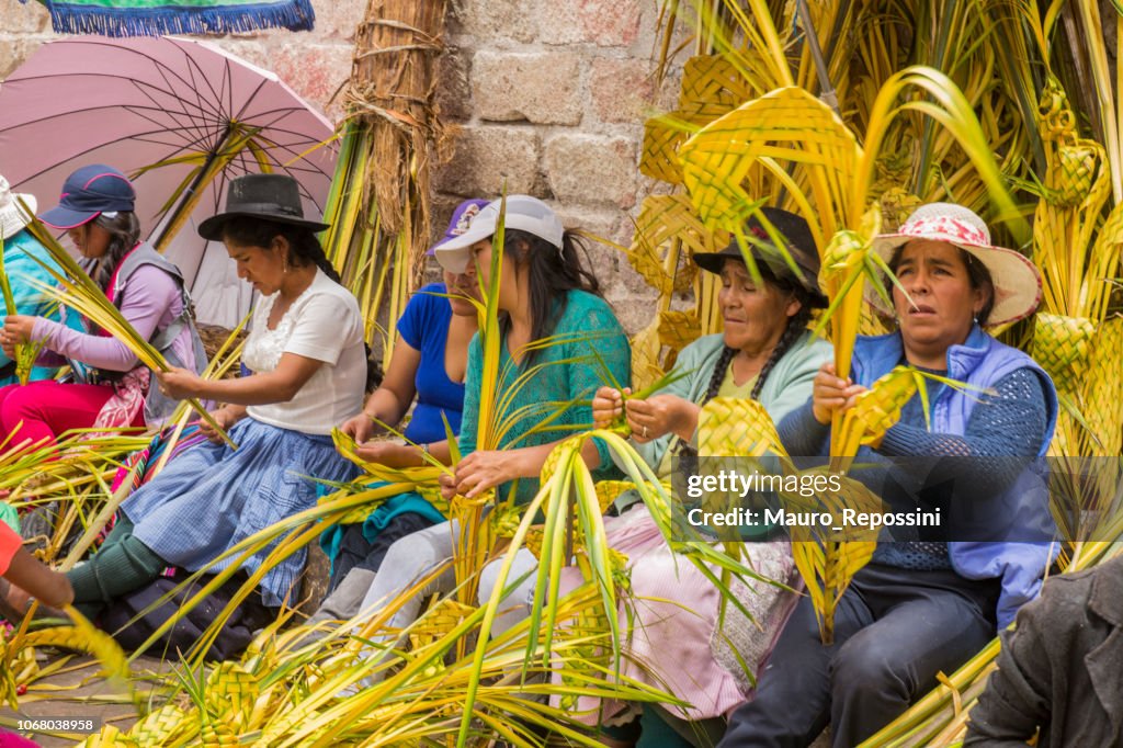 Mujeres y niños que se preparan ofrendas florales para celebrar el domingo de Ramos en Semana Santa en la ciudad de Ayacucho, Perú.