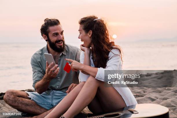 pareja de compras en línea en la playa - día de san valentín festivo fotografías e imágenes de stock