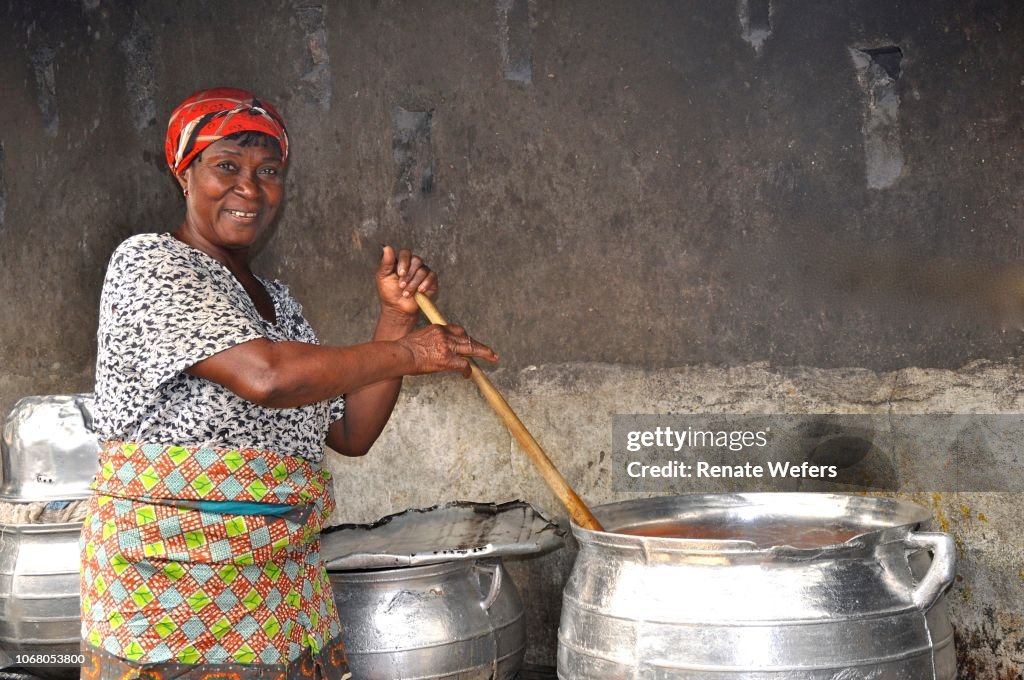 Portrait Of Smiling Mature Woman Preparing Food In Large Container