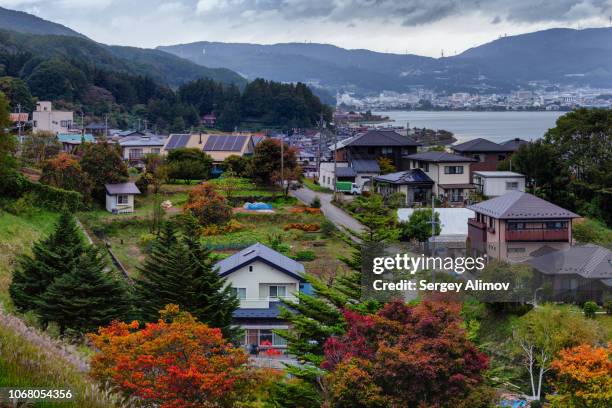 city of suwa on the lake suwako, japan - lake suwa stock-fotos und bilder