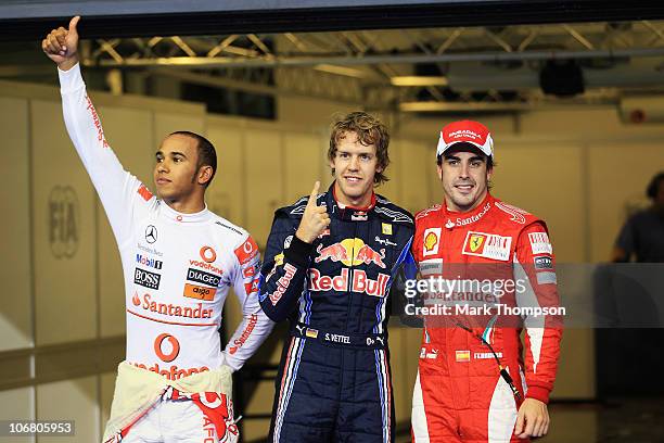 Pole sitter Sebastian Vettel of Germany and Red Bull Racing celebrates with second placed Lewis Hamilton of Great Britain and McLaren Mercedes and...