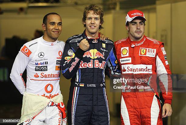 Pole sitter Sebastian Vettel of Germany and Red Bull Racing celebrates with second placed Lewis Hamilton of Great Britain and McLaren Mercedes and...