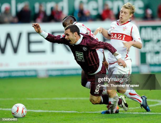 Christian Tiffert of Kaiserslautern battles for the ball with Arthur Boka and Patrick Funk of Stuttgart during the Bundesliga match between 1.FC...