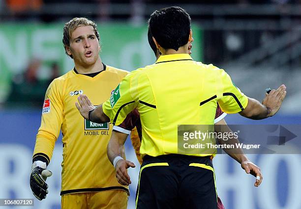 Referee Babak Rafati talks with the players of both teams during the Bundesliga match between 1.FC Kaiserslautern and VFB Stuttgart at...