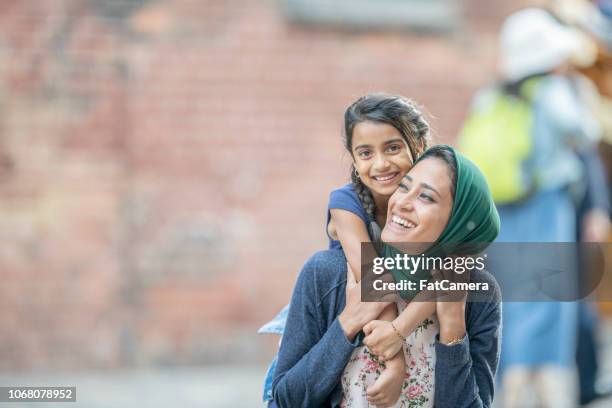 cabalgando sobre los hombros de mamá - islamic kids fotografías e imágenes de stock