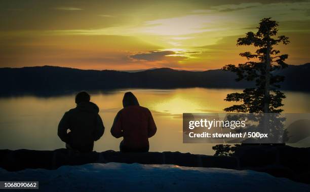 two people watching sunrise - crater lake stock pictures, royalty-free photos & images