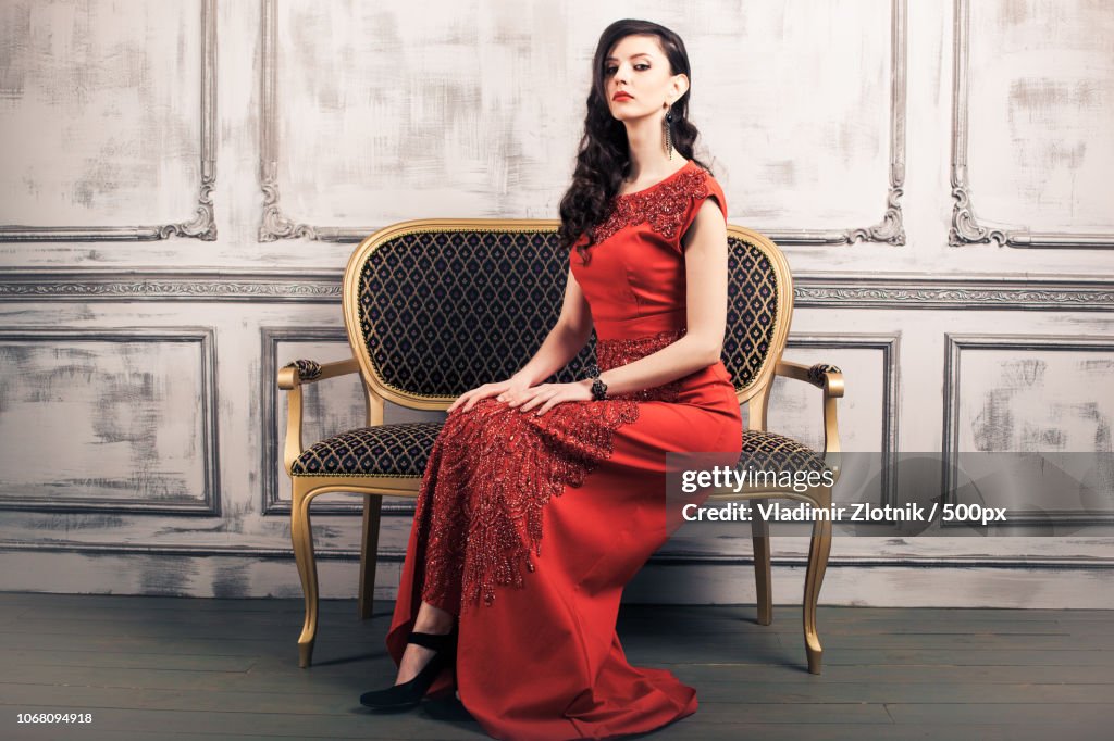 Portrait of young woman wearing red evening gown