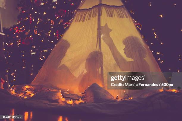 children in tent in front of christmas tree - camera bambino foto e immagini stock