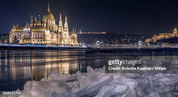 hungarian parliament by danube river at night in winter, budapest, hungary - budapest winter stock pictures, royalty-free photos & images