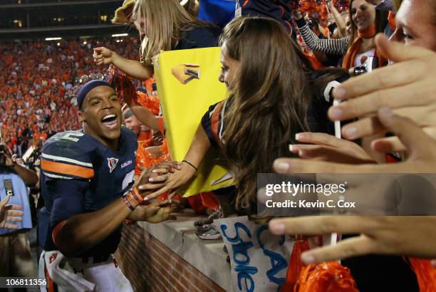 Quarterback Cameron Newton of the Auburn Tigers celebrates with fans after their 49-31 win over the Georgia Bulldogs at Jordan-Hare Stadium on...