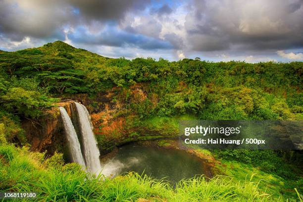 landscape of waterfall flowing in forest under dramatic sky - gold coast stock pictures, royalty-free photos & images