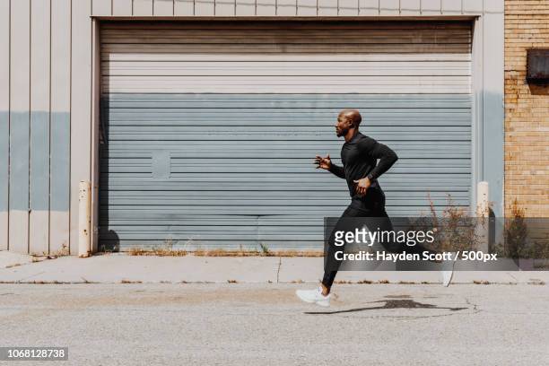 side view of man jogging in city - man running foto e immagini stock