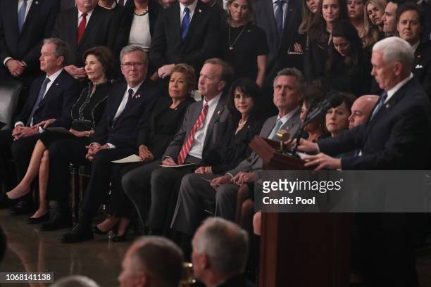 Former president George Bush, Laura Bush, Jeb Bush, Jeb’s wife Columba Bush, Neil Bush, his wife Maria, and Marvin Bush listen to Vice President Mike...