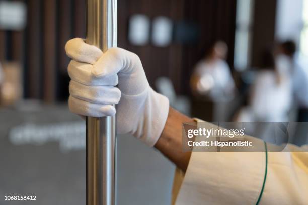 close up of unrecognizable bellhop holding luggage cart - bell boy stock pictures, royalty-free photos & images