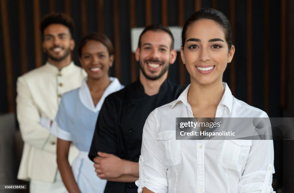 Gerente de mulher bonita e sua equipe atrás de tudo olhando para câmera sorrindo