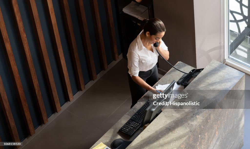Latijns-Amerikaanse hotelreceptionist nemen een phonecall