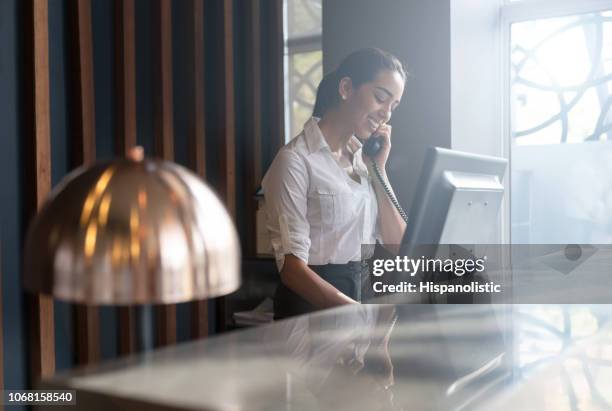 bellissimo receptionist dell'hotel amichevole che risponde a una chiamata di un ospite - booking hotel foto e immagini stock