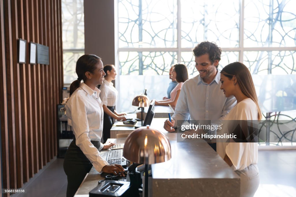 People at a hotel enjoying their vacation checking in filling a form
