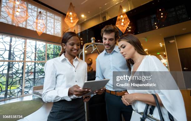 mooie hotelmanager tonen van sommige touristis-sites te koppelen alle tablet gelukkig kijken - hotel manager stockfoto's en -beelden