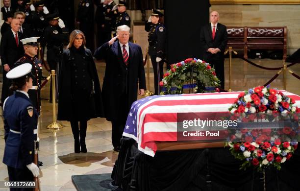 President Donald Trump salutes alongside first lady Melania Trump as they pay their respects to former U.S. President George H.W. Bush at the U.S...