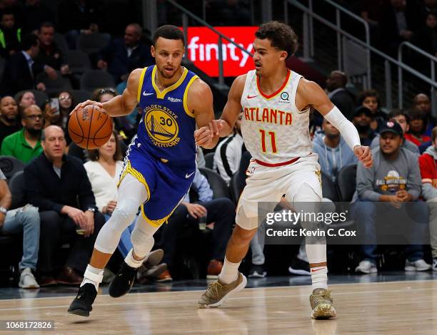 Stephen Curry of the Golden State Warriors drives against Trae Young of the Atlanta Hawks at State Farm Arena on December 3, 2018 in Atlanta,...