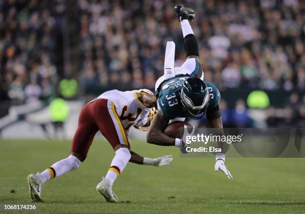 Running back Josh Adams of the Philadelphia Eagles carries the ball as he is tackled by cornerback Greg Stroman of the Washington Redskins in the...