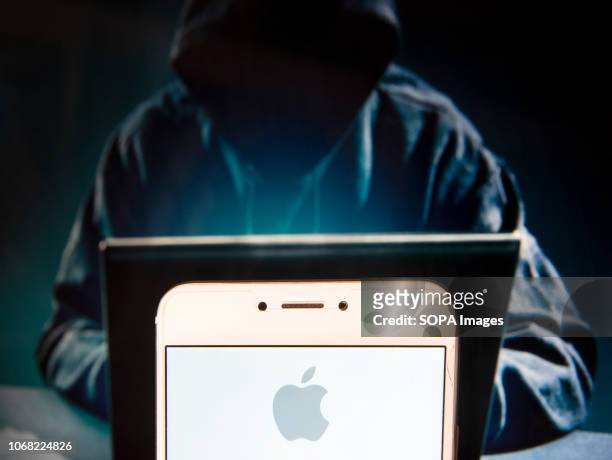In this photo illustration, the American multinational technology company Apple logo is seen displayed on an Android mobile device with a figure of...